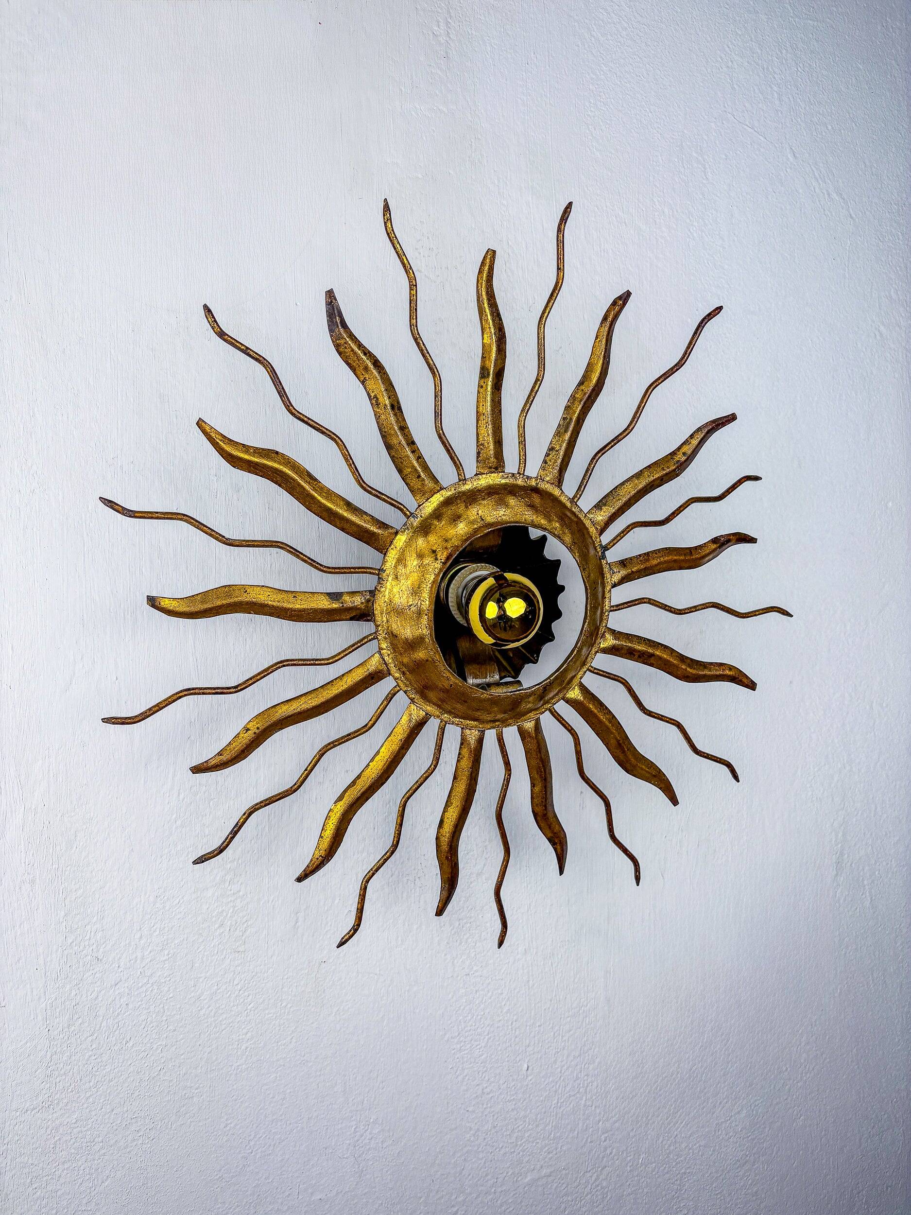 Brutalist sunburst ceiling light – gilt iron rays & exposed bulb, France, 1960s
