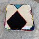 Berber floor pouf: Handwoven Moroccan wool cushion.