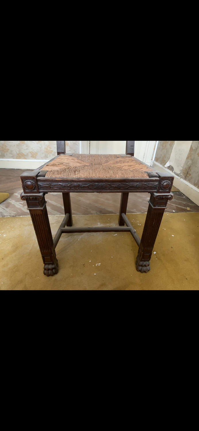 Antique carved wooden chairs with straw seats.