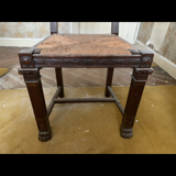 Antique carved wooden chairs with straw seats.