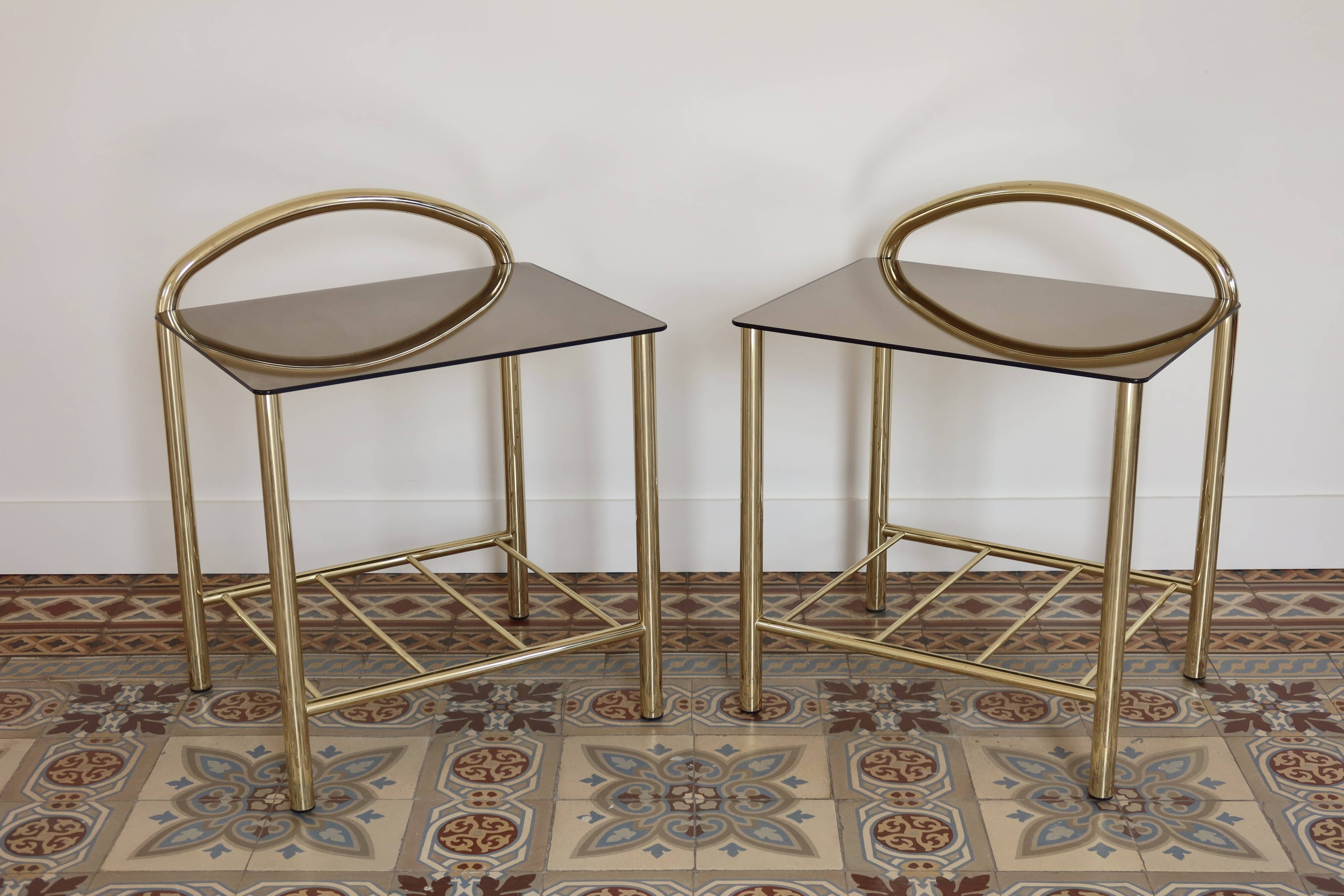 Pair of bedside tables with gold metal and mirrored glass top.