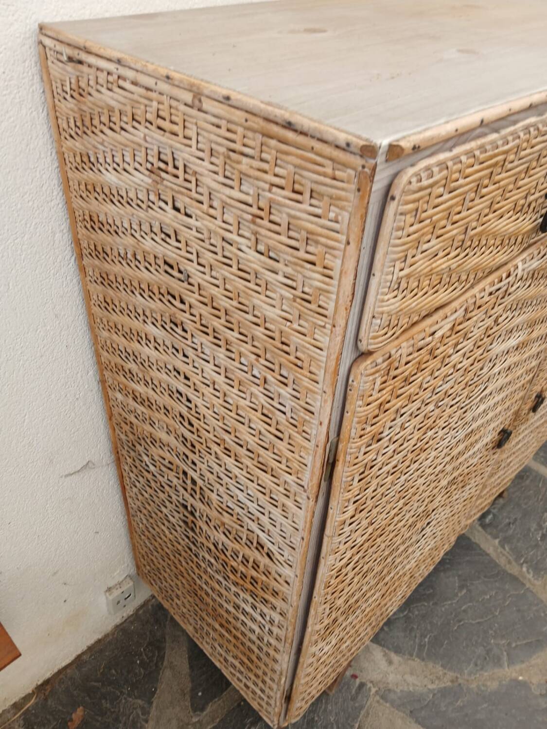 Vintage woven rattan furniture with tapered legs.