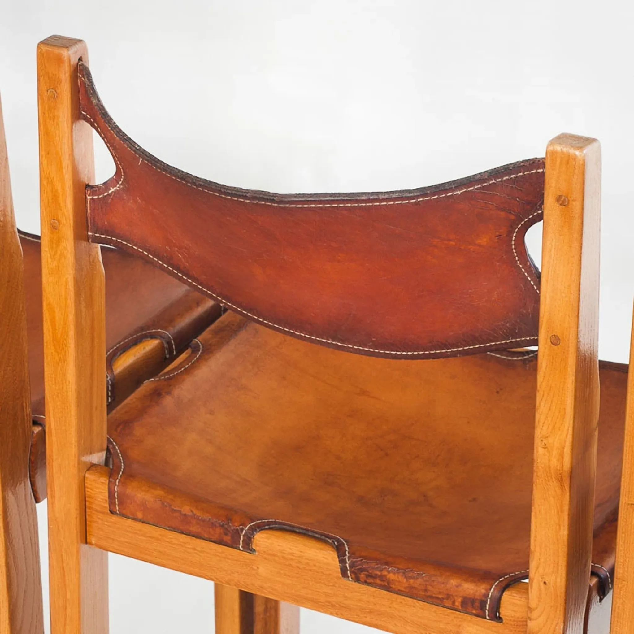 Ensemble de quatre chaises vintage. Bois d'orme et cuir. Maison Regain 70s
