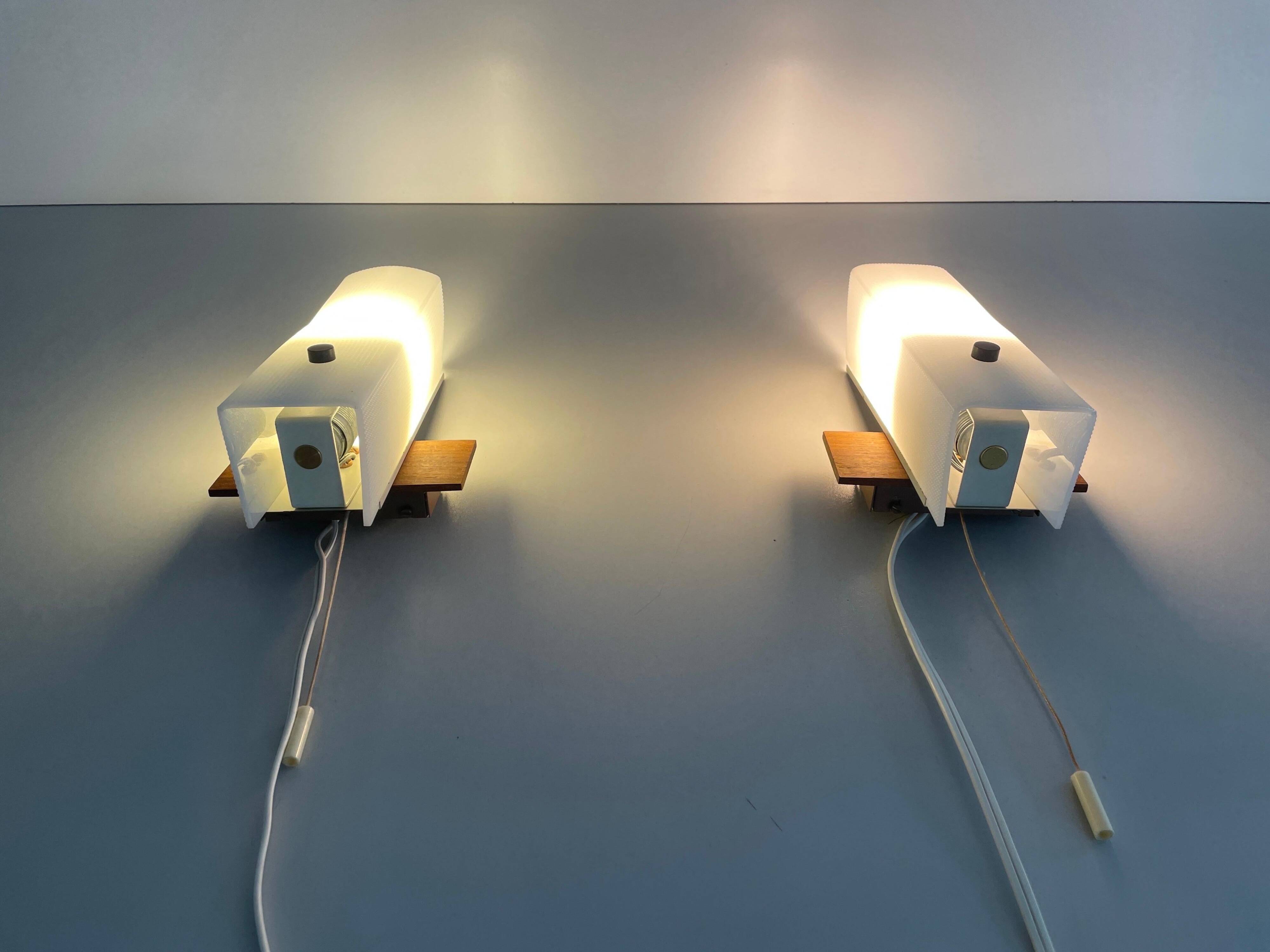 Mid-century wall lights in white plexiglass with a wooden base, 1960s, Germany.