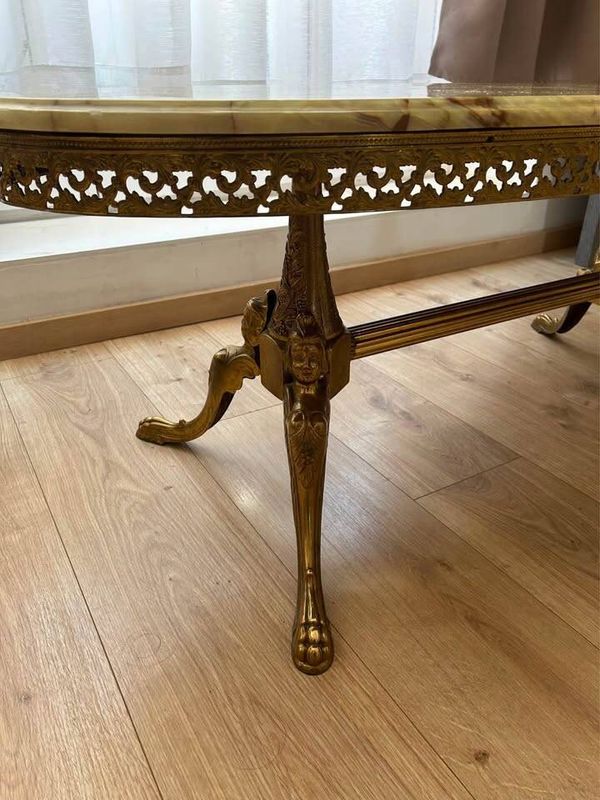 Table basse ovale en onyx de style Hollywood Regency avec base en laiton doré.