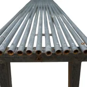 Long metal bench with tubular seat