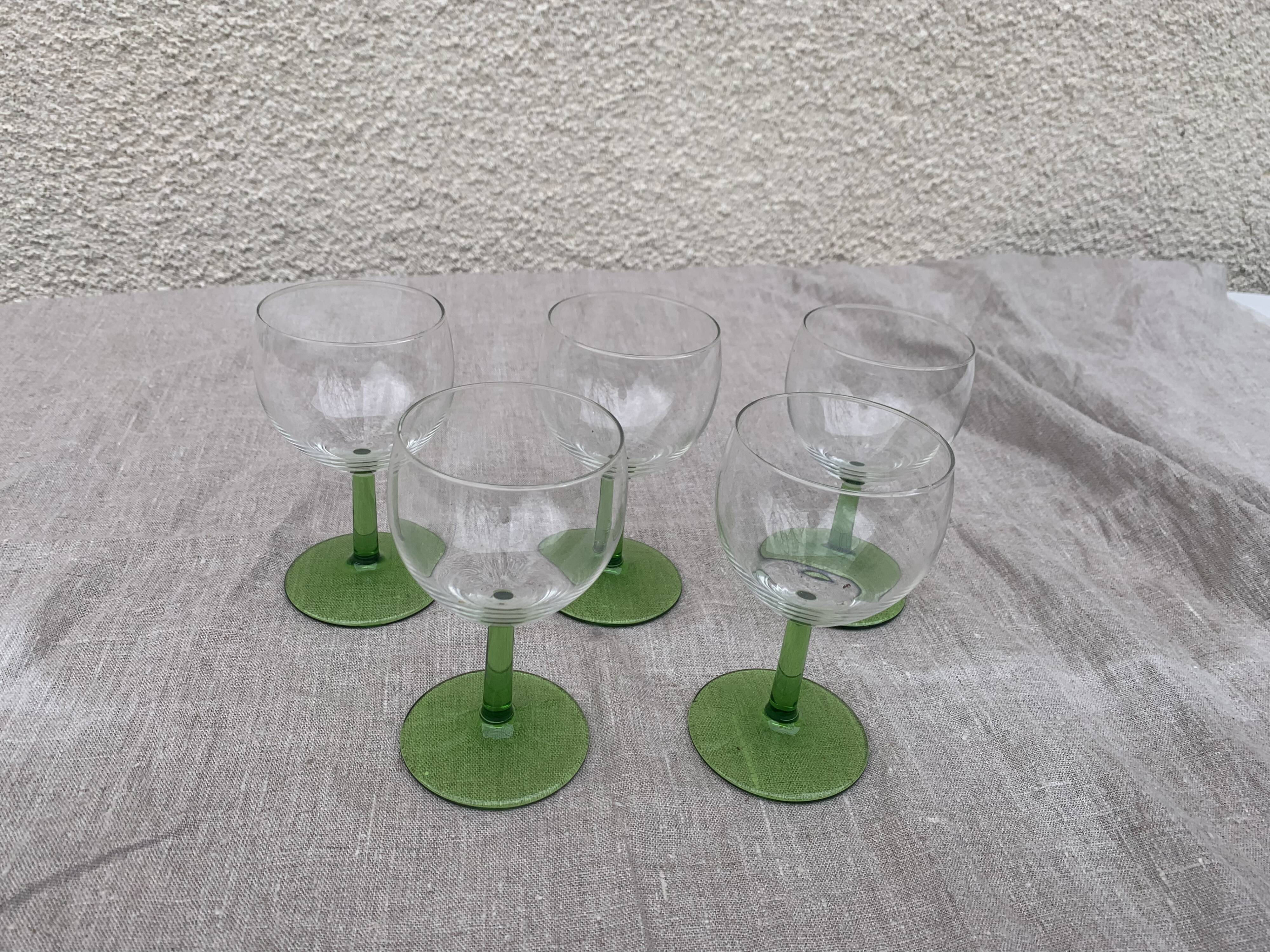 5 transparent glass glasses and green glass vase go