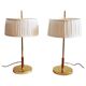 Paire de lampes de bureau suédoises en laiton avec des détails en cuir et des abat-jours blancs.