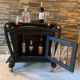 Renovated vintage bar cart in black and copper with removable serving tray.