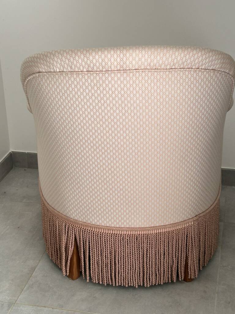 Pink armchair with patterns and fringes.