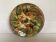 Ceramic catchall with flowers, fruits, and leaves.