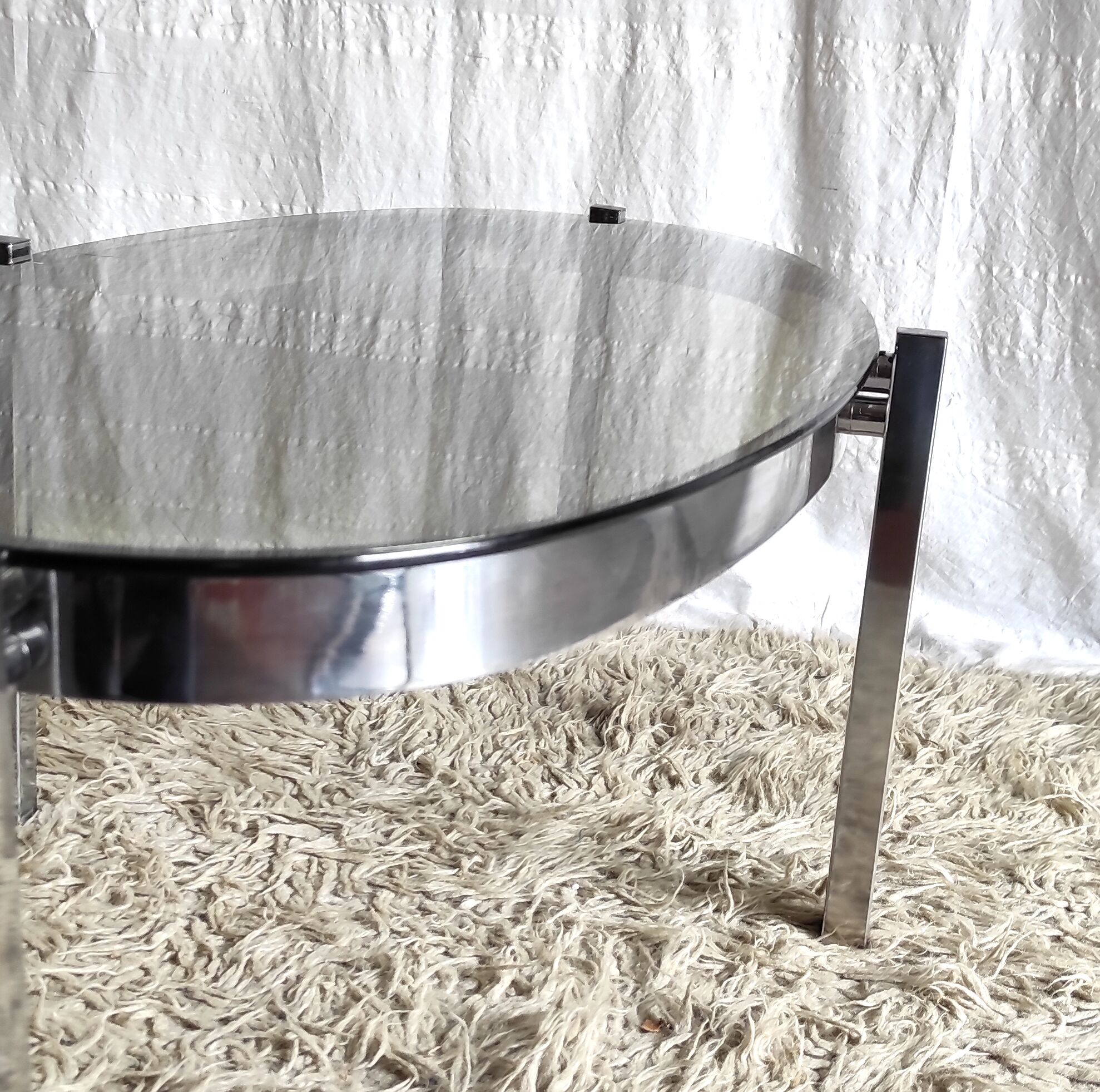 Table basse de forme élyptique en metal chomé et verre fumé, années 70