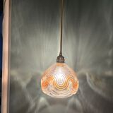 Suspension with amber moulded glass globe featuring wavy patterns.