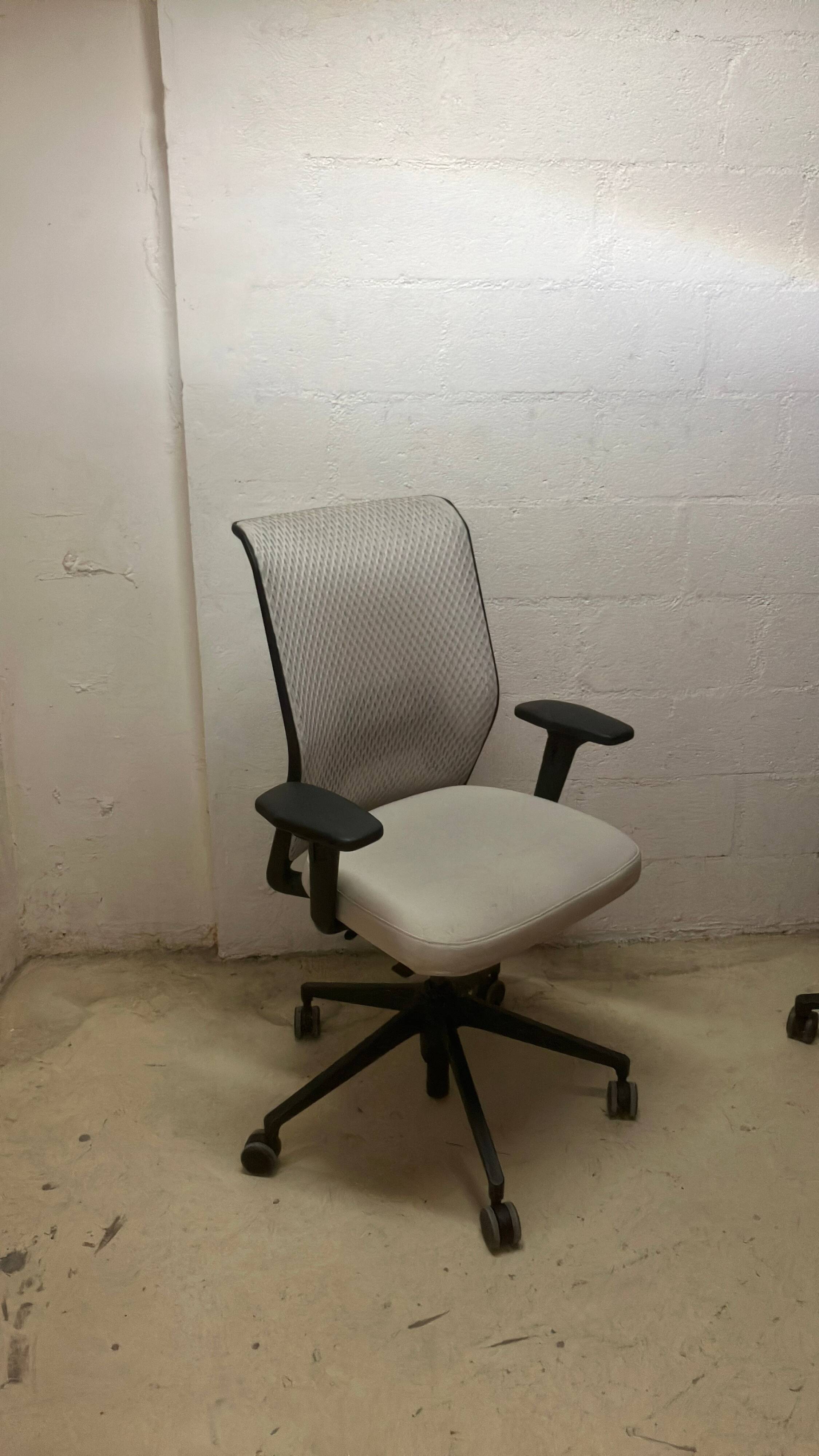 Office chair with wheels and mesh backrest.