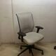 Office chair with wheels and mesh backrest.