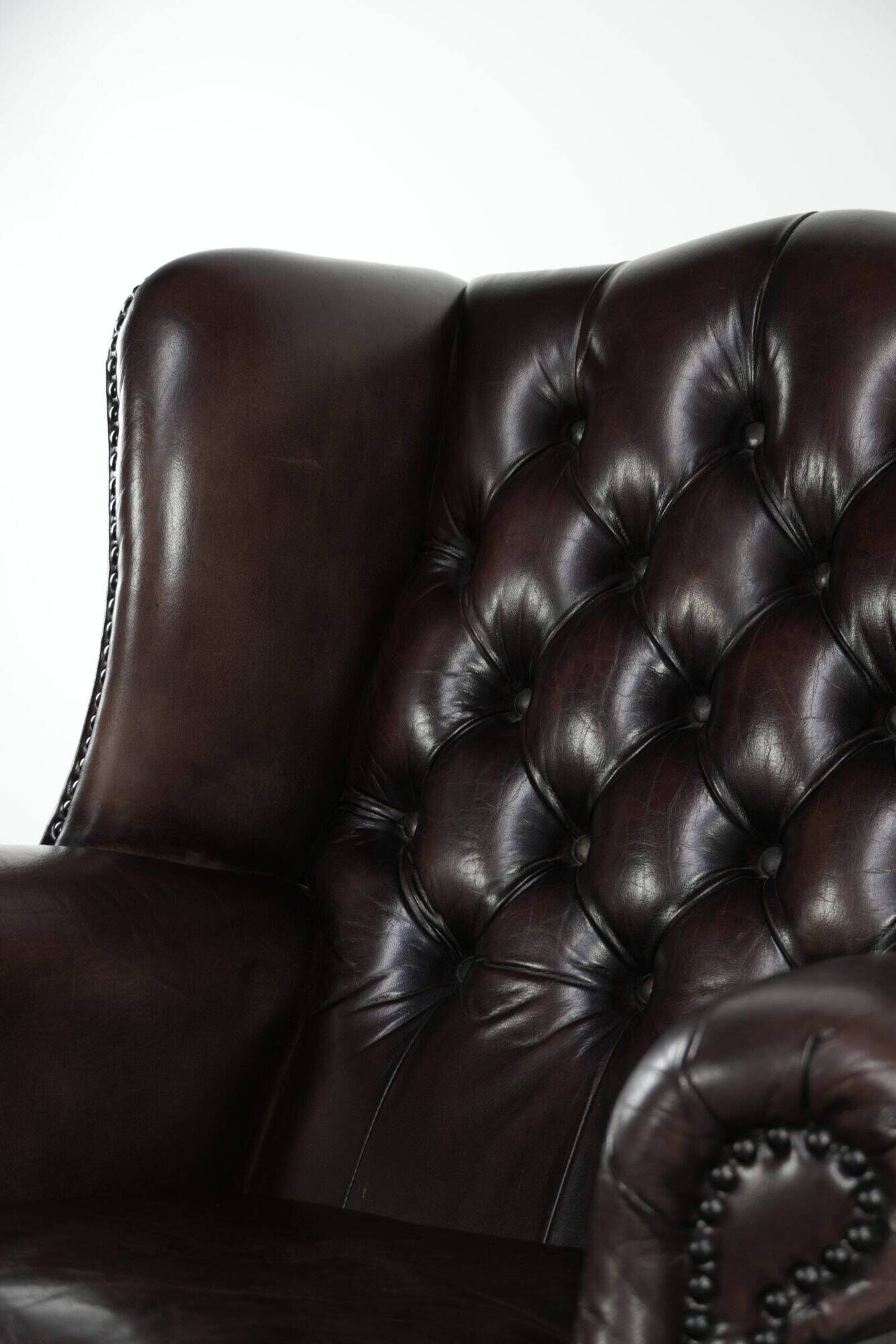 Dark brown cowhide Chesterfield wingback armchair in classic English style
