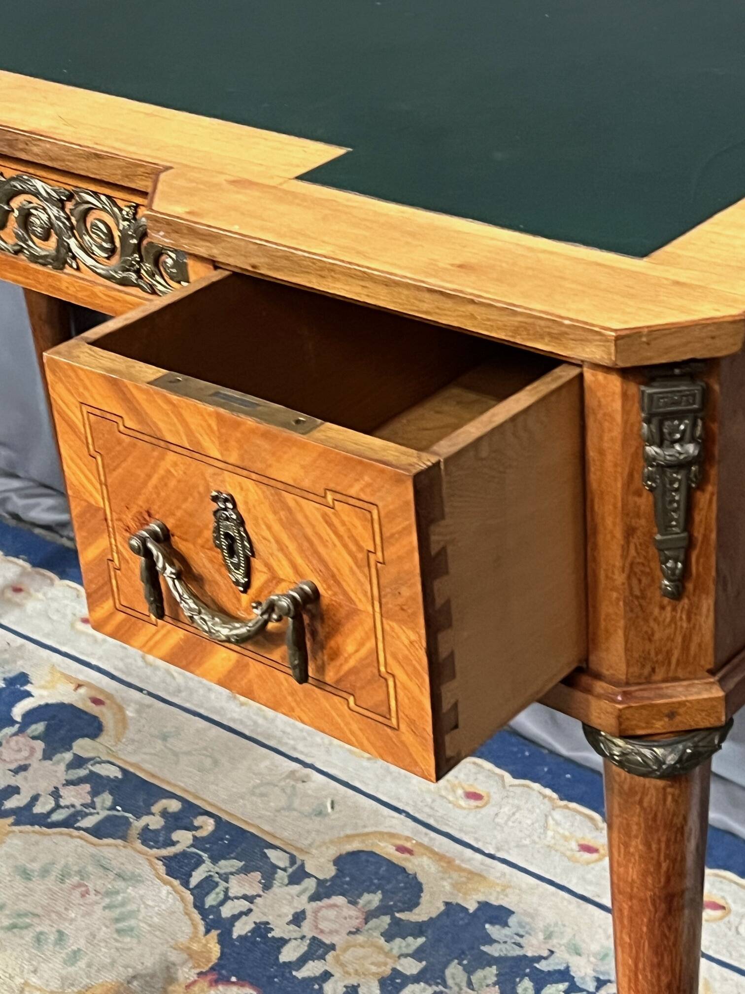Louis XVI style marquetry desk. The top is decorated with green leather.