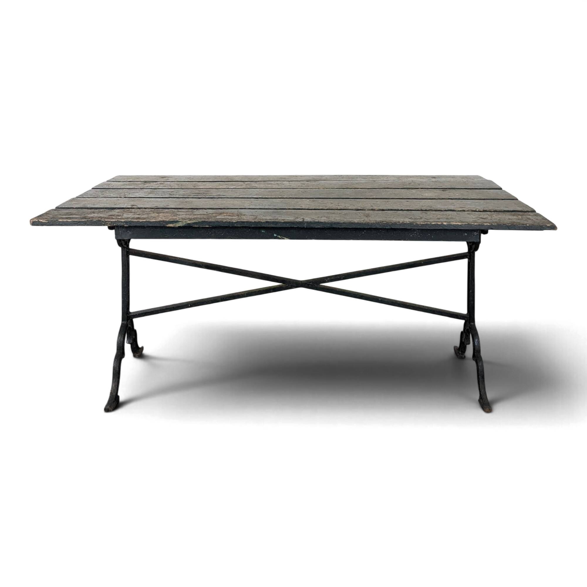 Garden table with a cast iron base and a green painted wooden top.