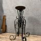 Wrought iron candlestick on four-legged base circa 1900-1930
