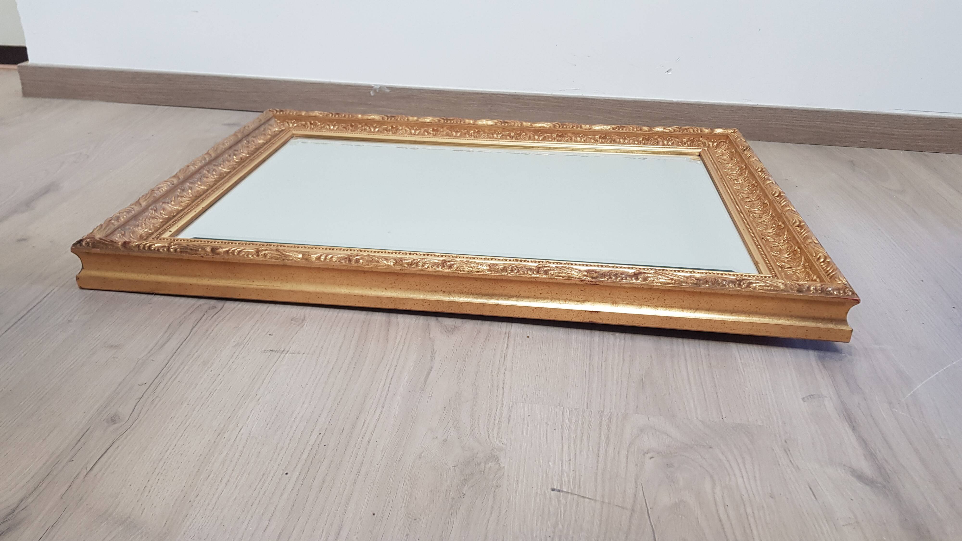 Mirror in gilded stucco wood and beveled glass