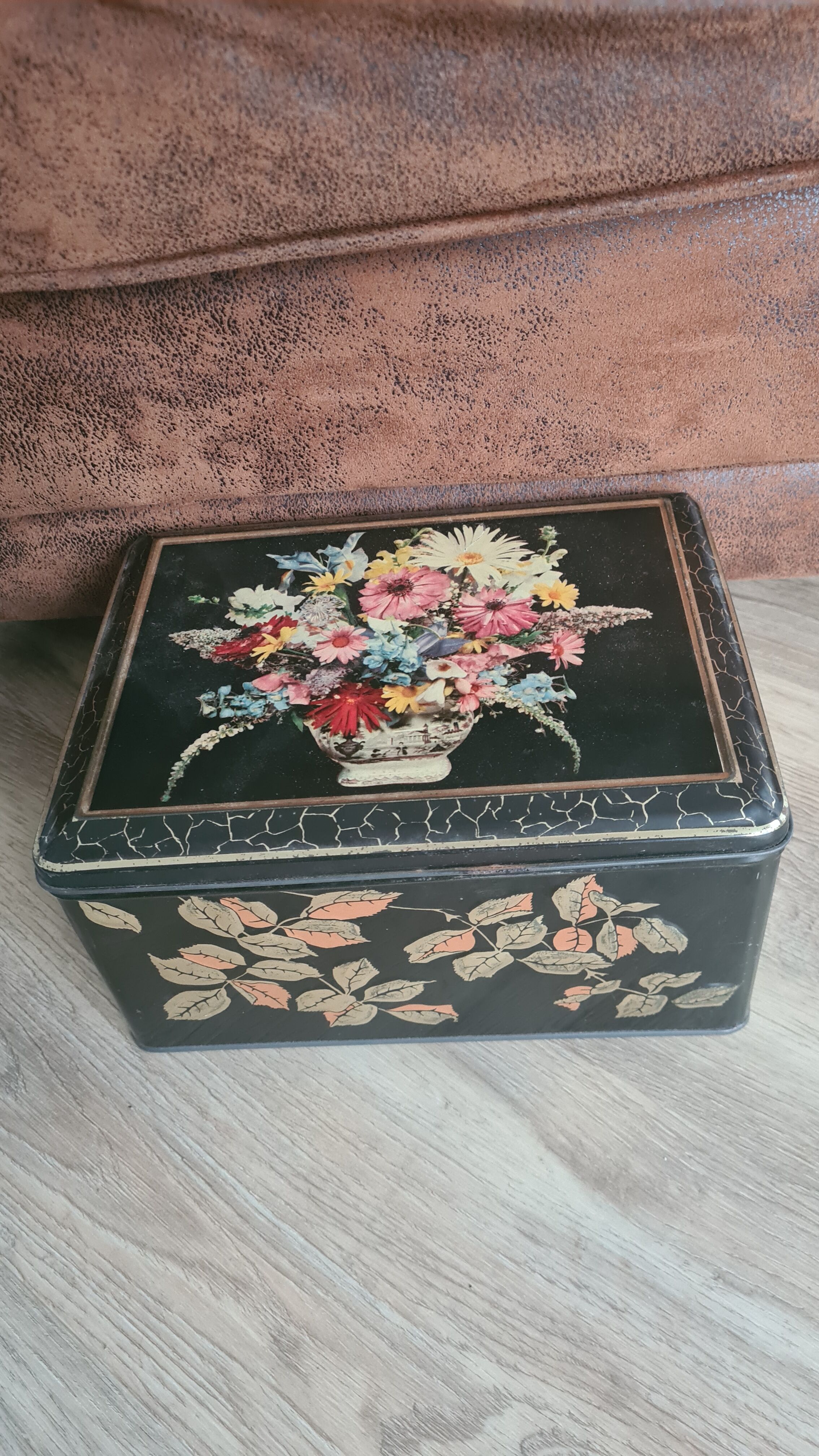Old black metal box and flowers at the beginning of the century