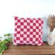 Berber cushion with a pink checkerboard pattern.