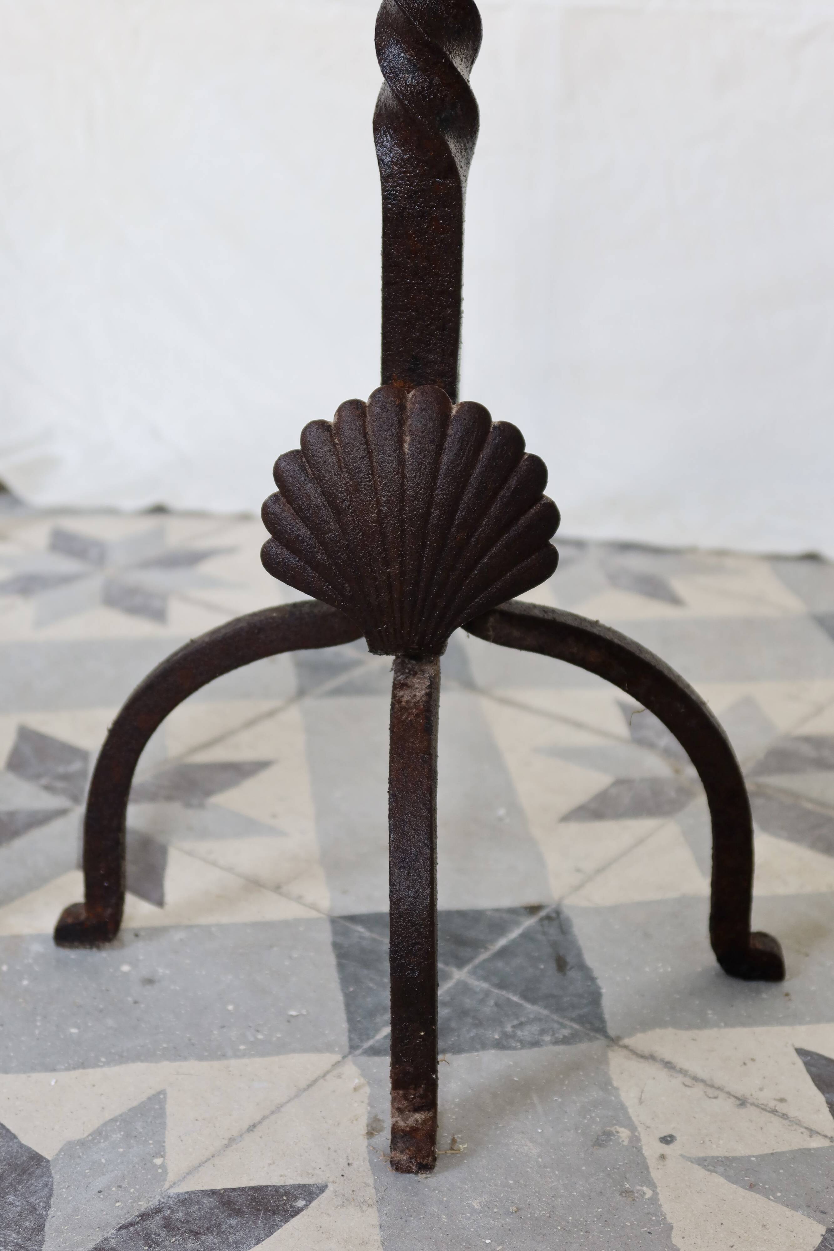 Vintage metal and cast iron fire dogs with shell motif.