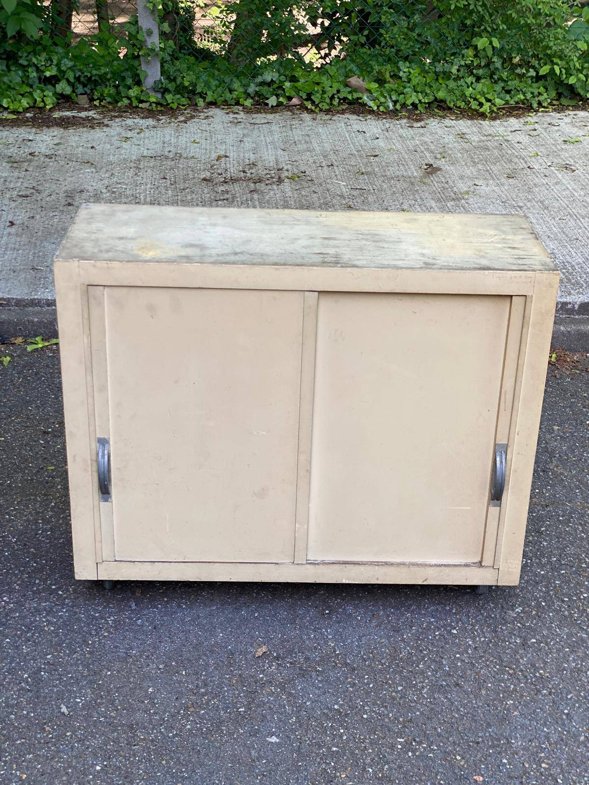 Beige wooden storage cabinet on wheels in industrial style.