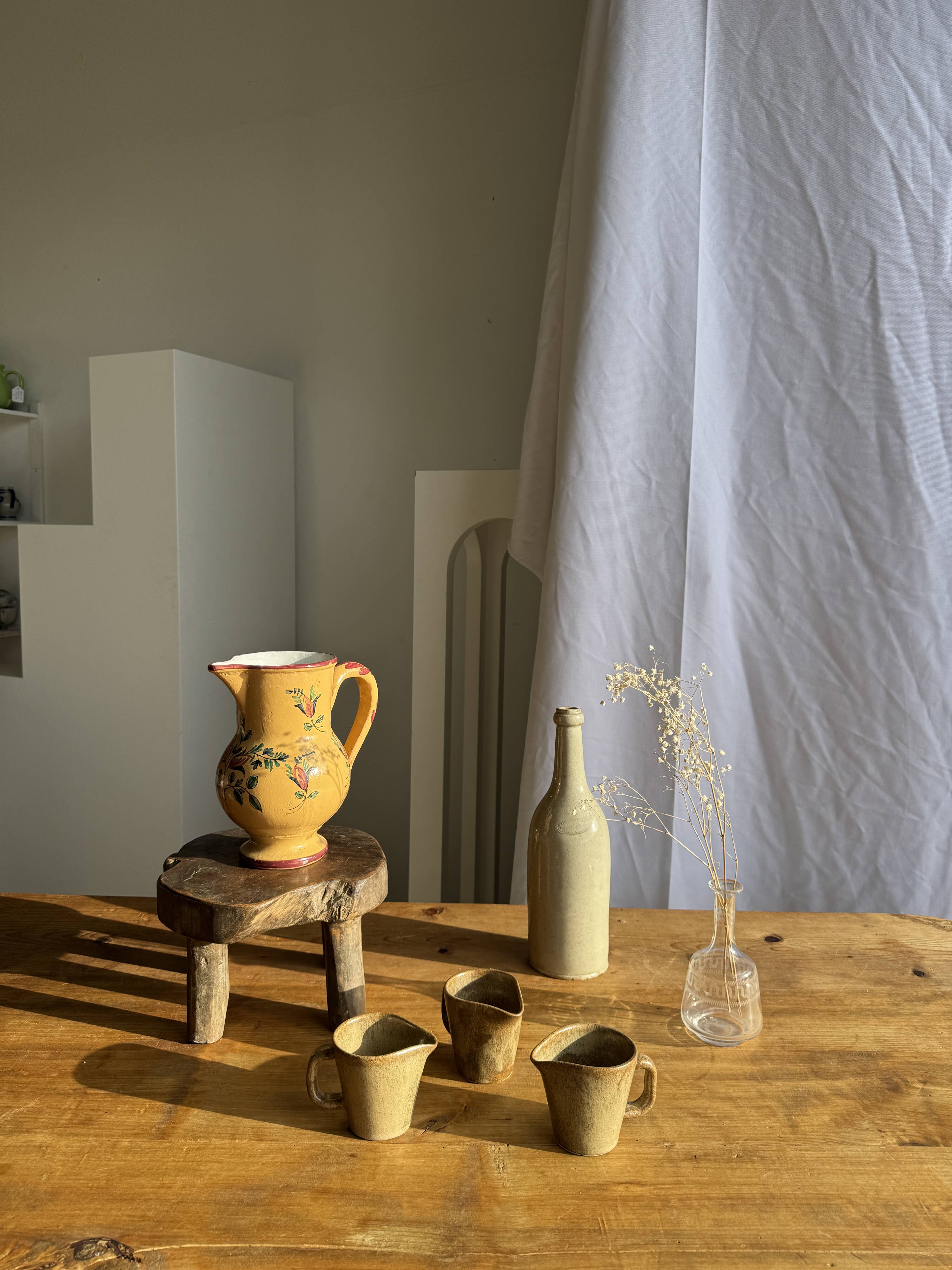Large antique handmade ochre yellow jug with a pink flower pattern.