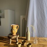 Large antique handmade ochre yellow jug with a pink flower pattern.