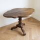 Antique wooden gueridon with a scalloped top.
