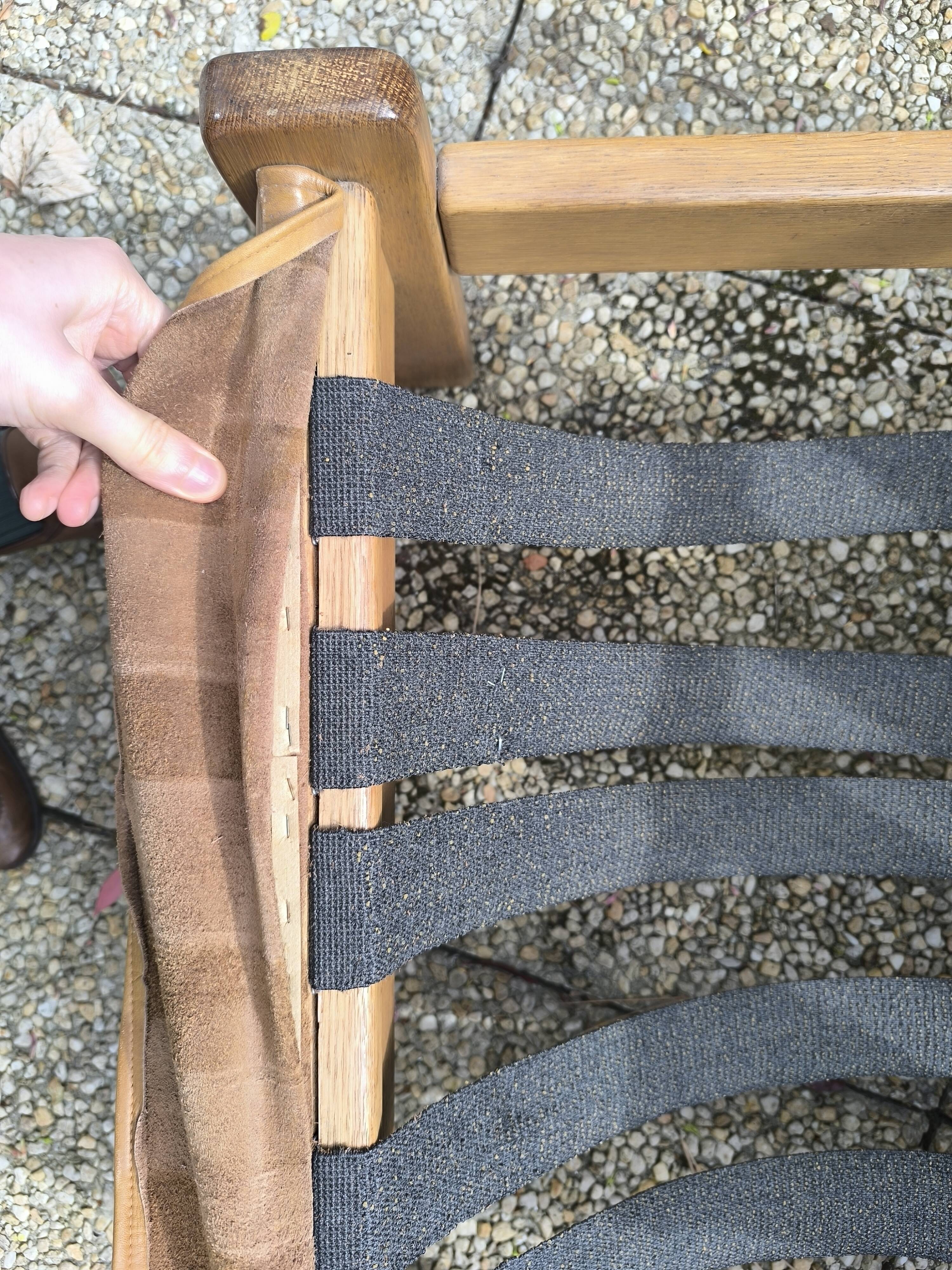 Pair of solid wood and leather lounge chairs, European work, circa 1970.