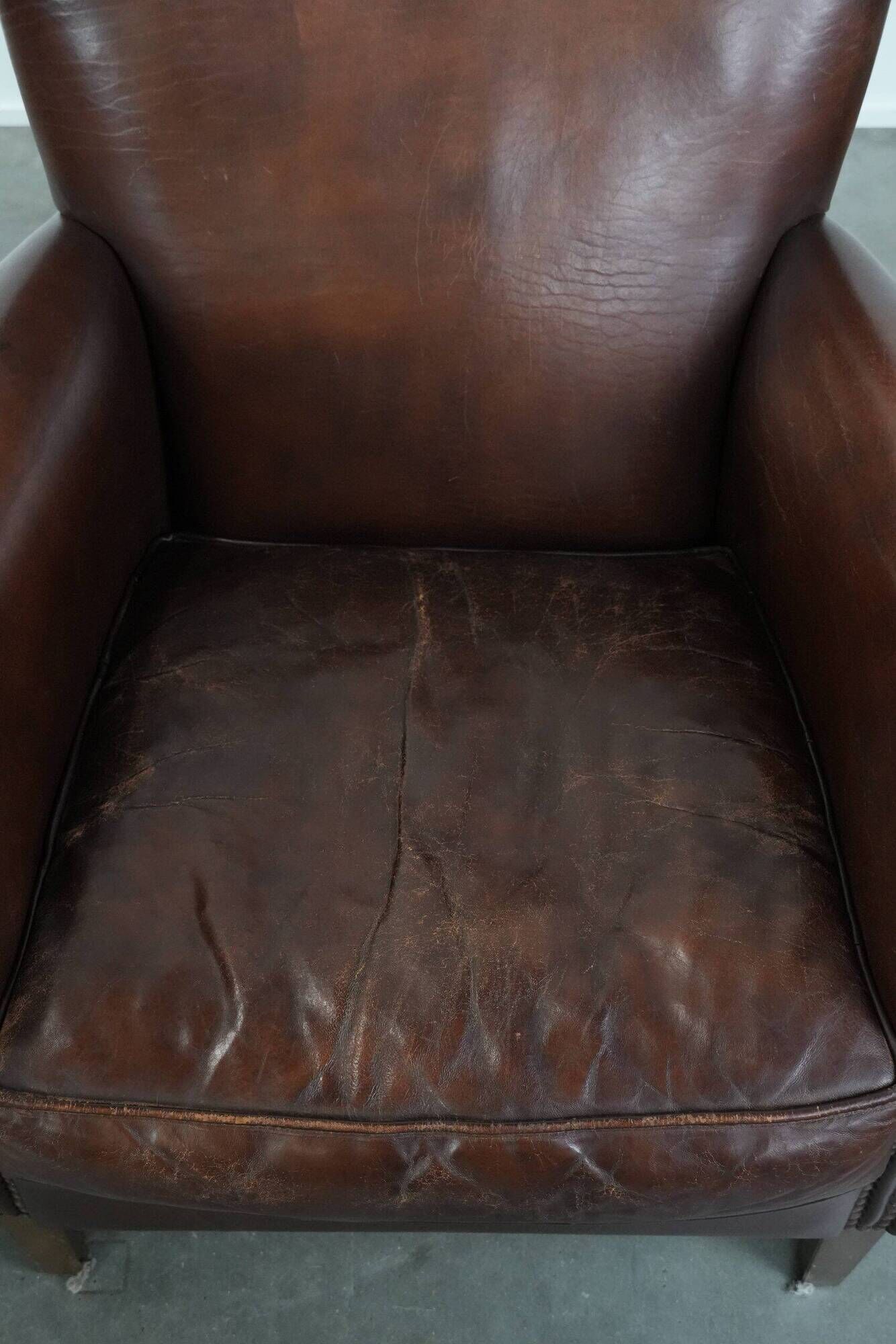 Ensemble de deux fauteuils en cuir de mouton vintage au caractère marqué.
