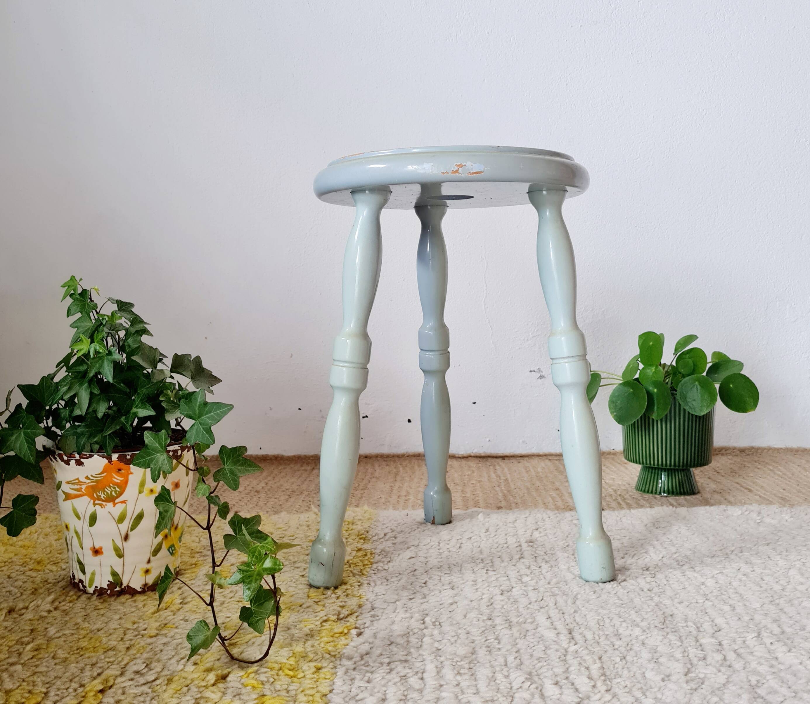 Antique tripod stool made of solid wood in blue.