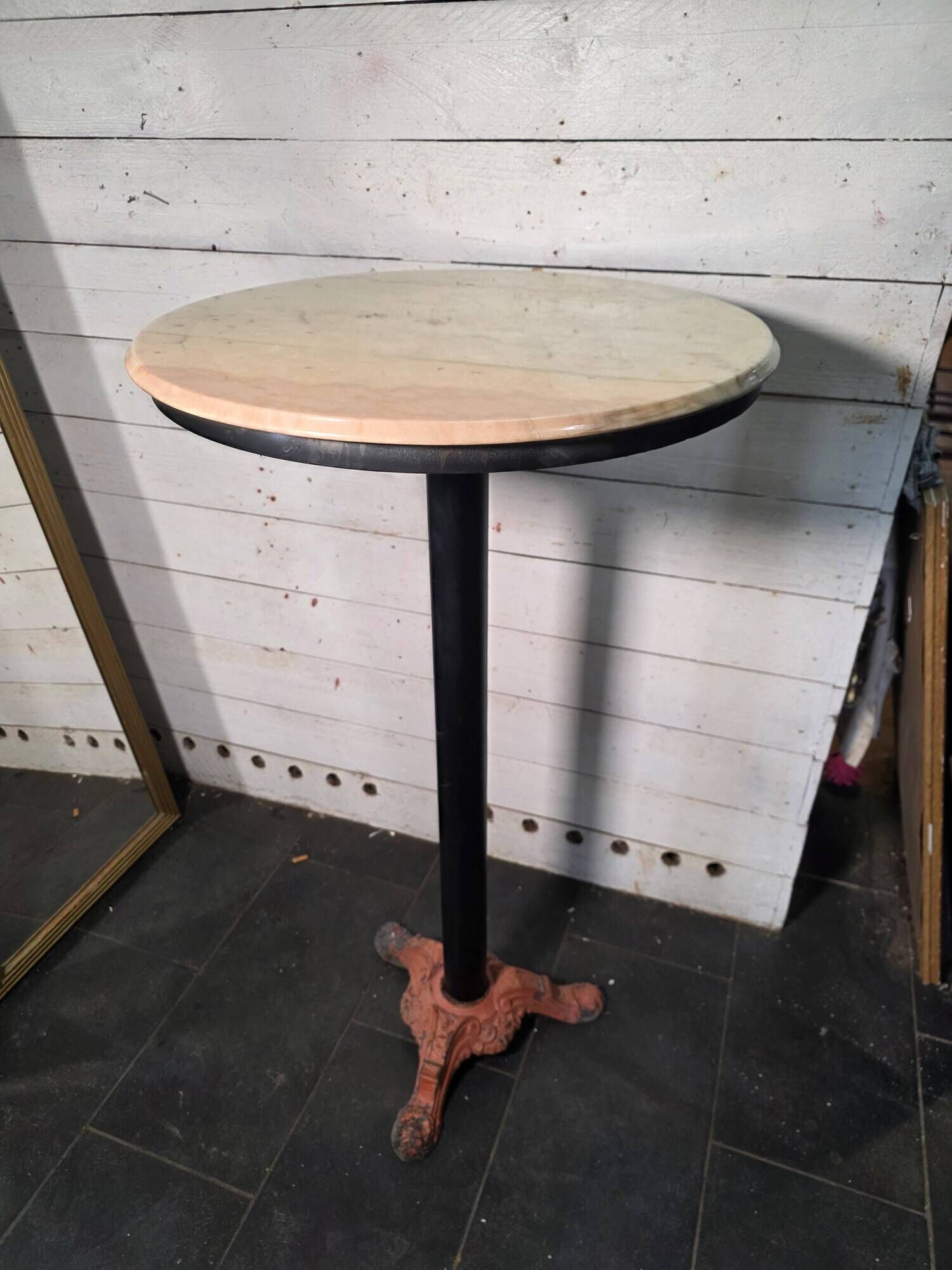 Bistro standing table with marble top and cast iron base.