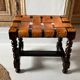 Antique turned wooden stool with woven leather.