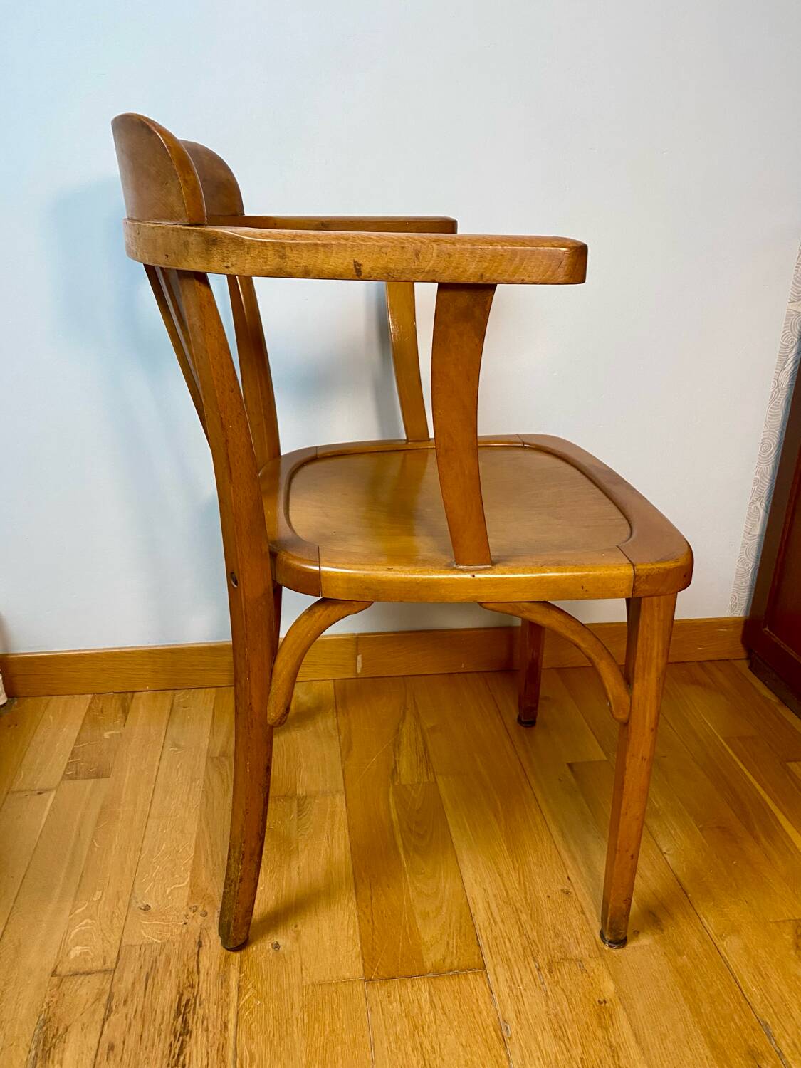 Antique curved wooden armchair in Baumann style