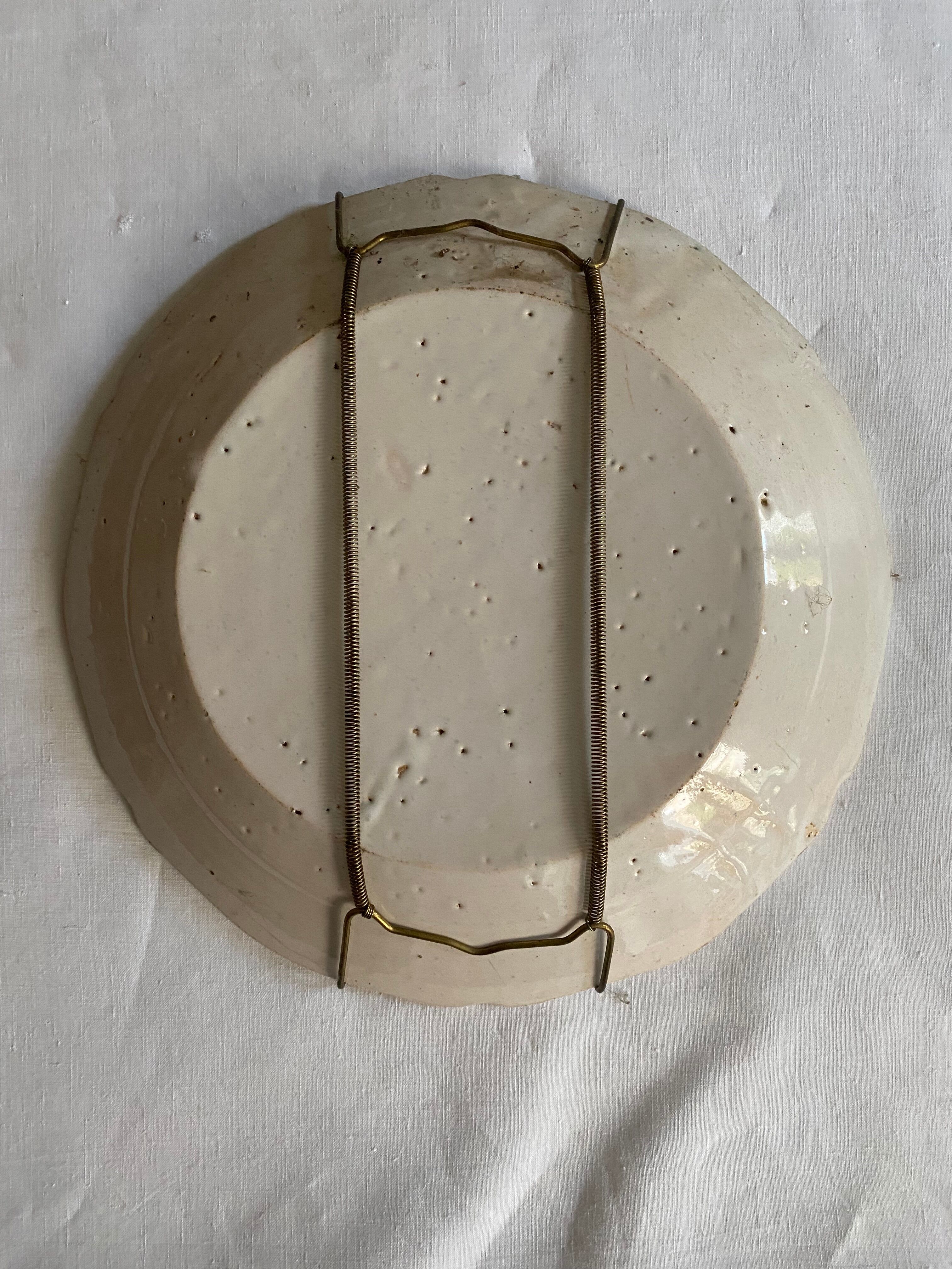 Plate of Nevers in earthenware late eighteenth century decoration of crest to flower