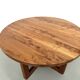 Modernist round table in solid elm, crossed legs.