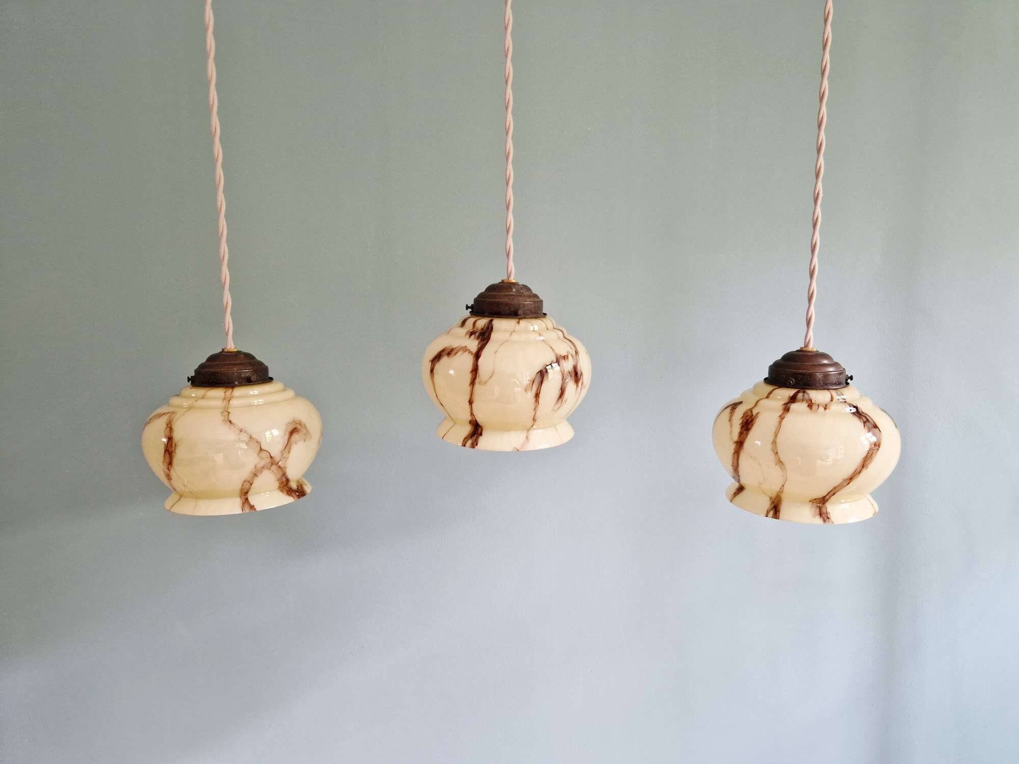 Trio of Art Deco marbled opaline pendant lights, 1920-30