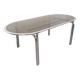 Vintage oval dining table in smoked glass and chrome metal, Space Age style.