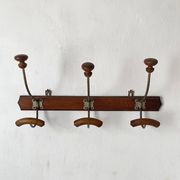Old wooden and metal wall-mounted coat rack.