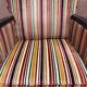 Art Deco armchair in multicolored striped fabric and its footrest