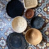 Set of 7 black and natural wicker baskets.