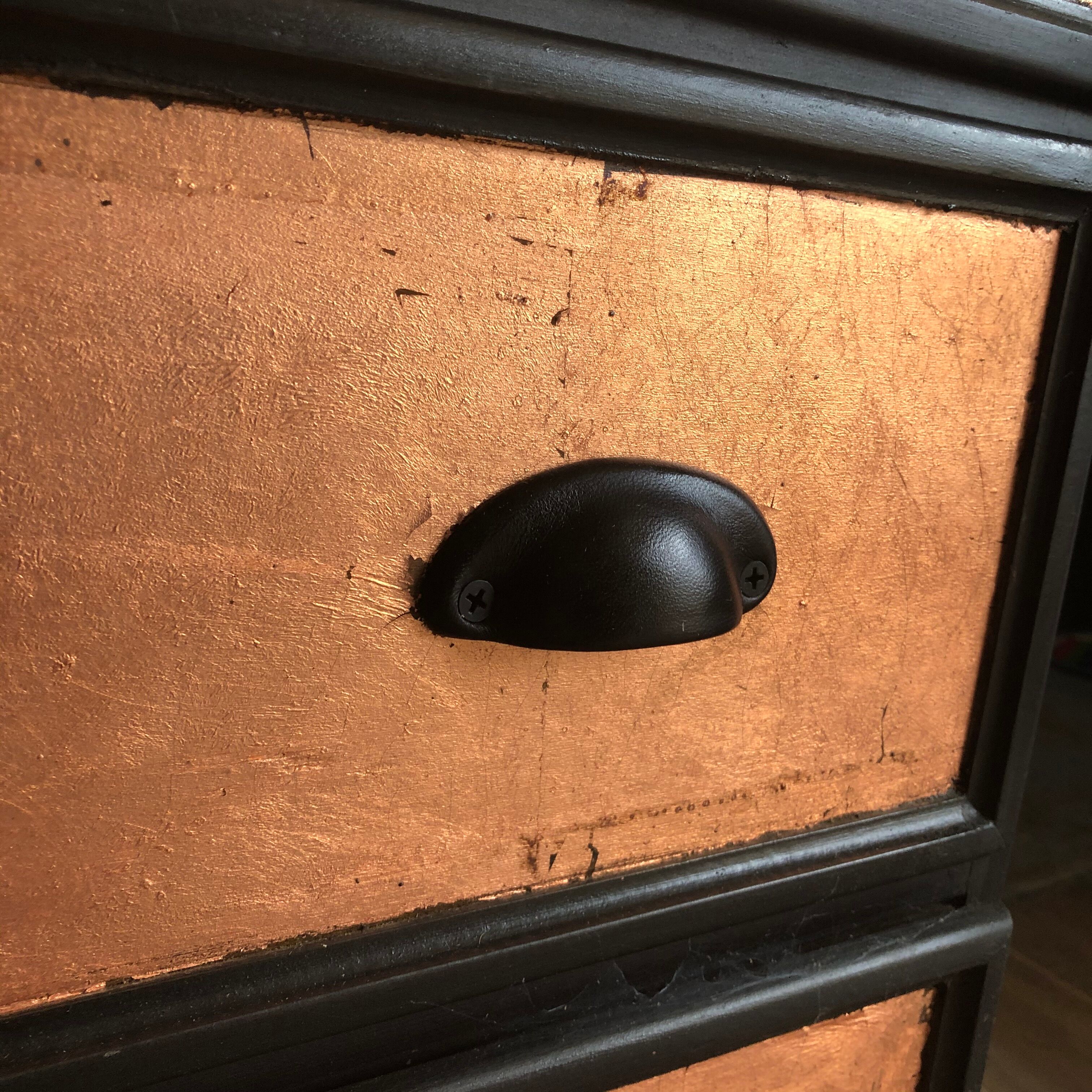 Commode noire et feuilles de cuivre