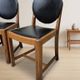 Set of four vintage wooden dining chairs with black leather upholstery