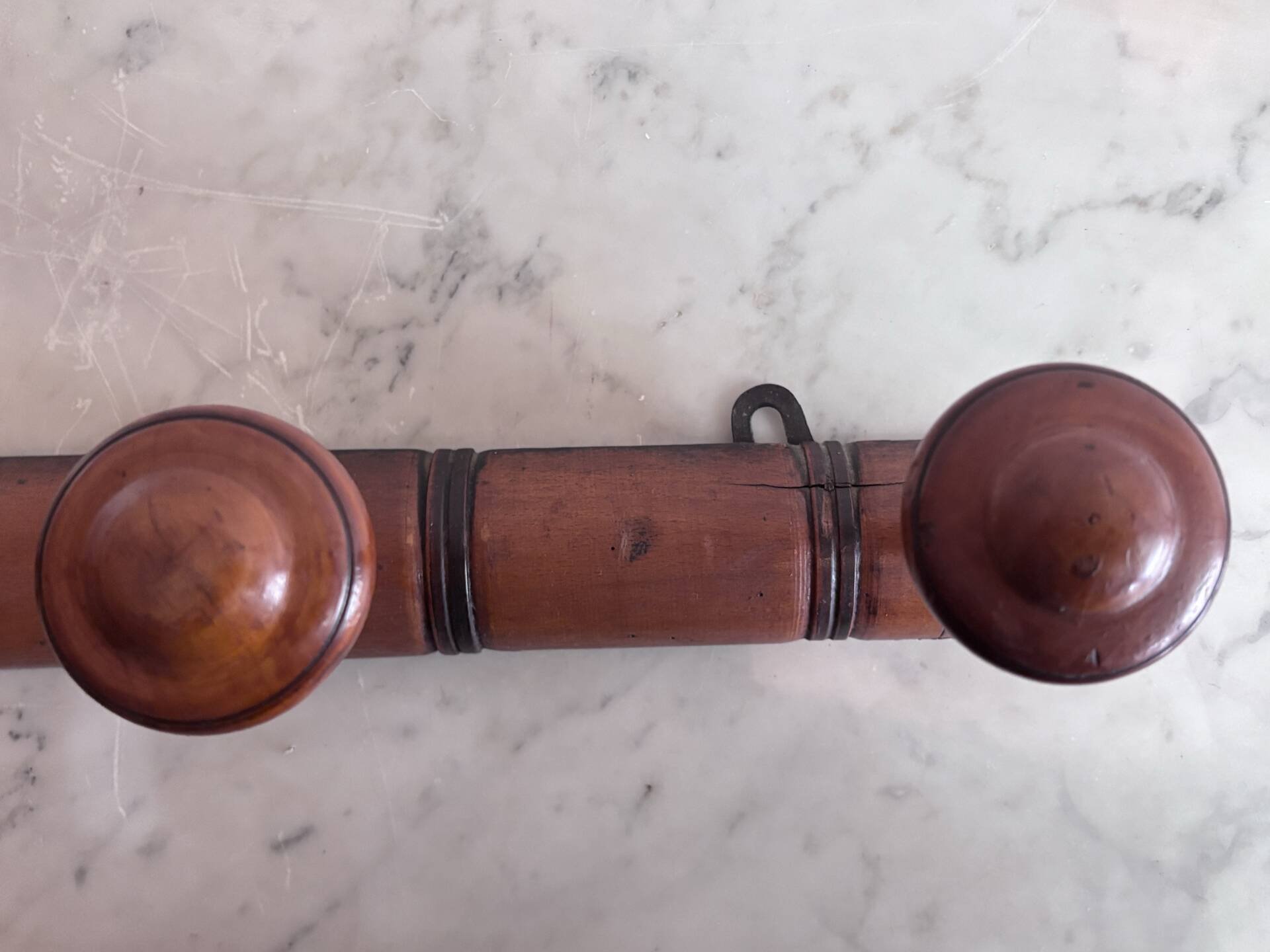 Wall-mounted coat rack with 8 turned wooden hooks in faux bamboo style.
