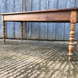 Antique farmhouse table in solid cherry wood with turned legs.