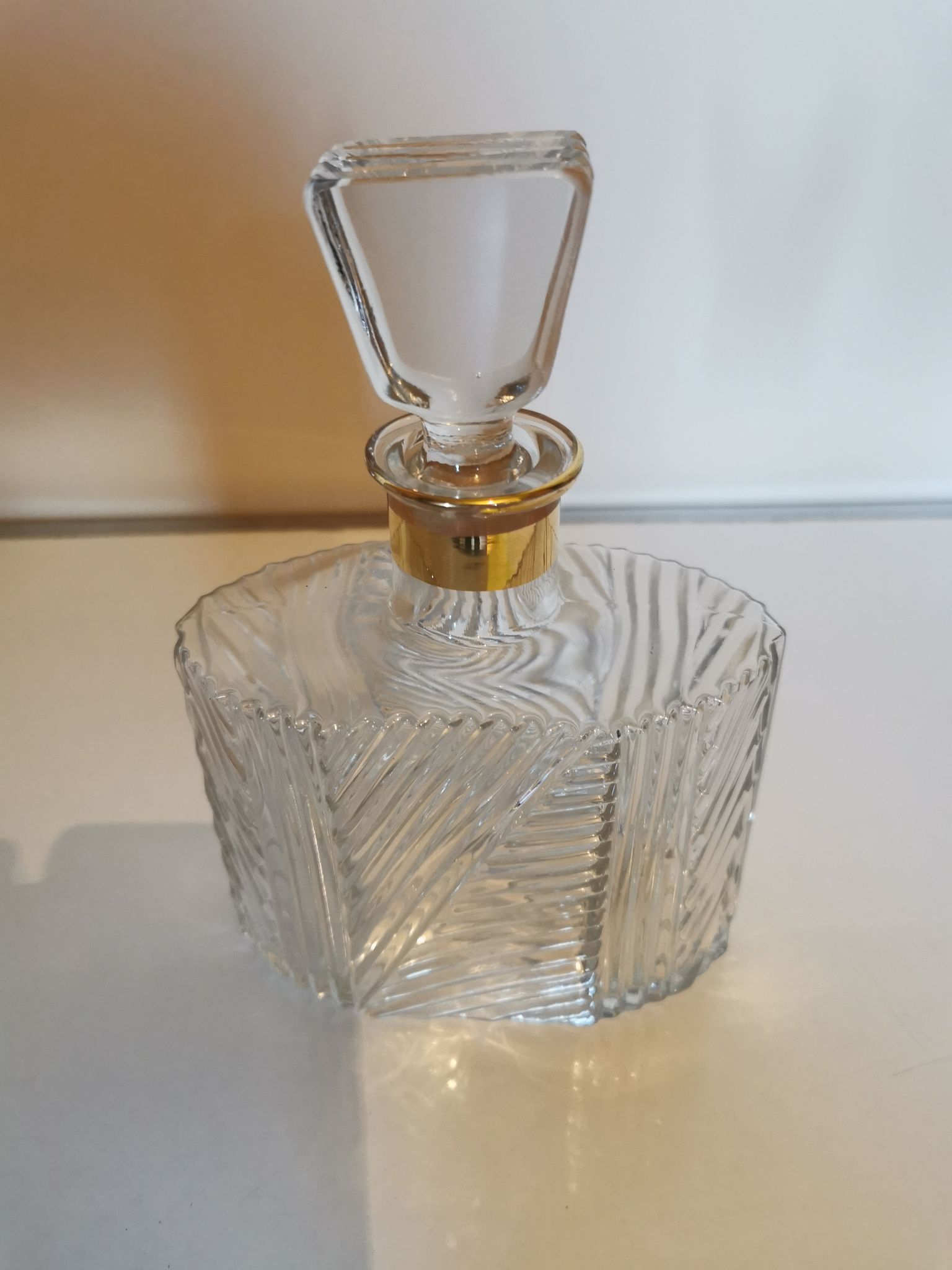 Cut glass carafe with a gold band on the neck.