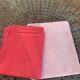 Duo set, consisting of two large pink-dyed cotton and linen towels, embroidered, TK monograms